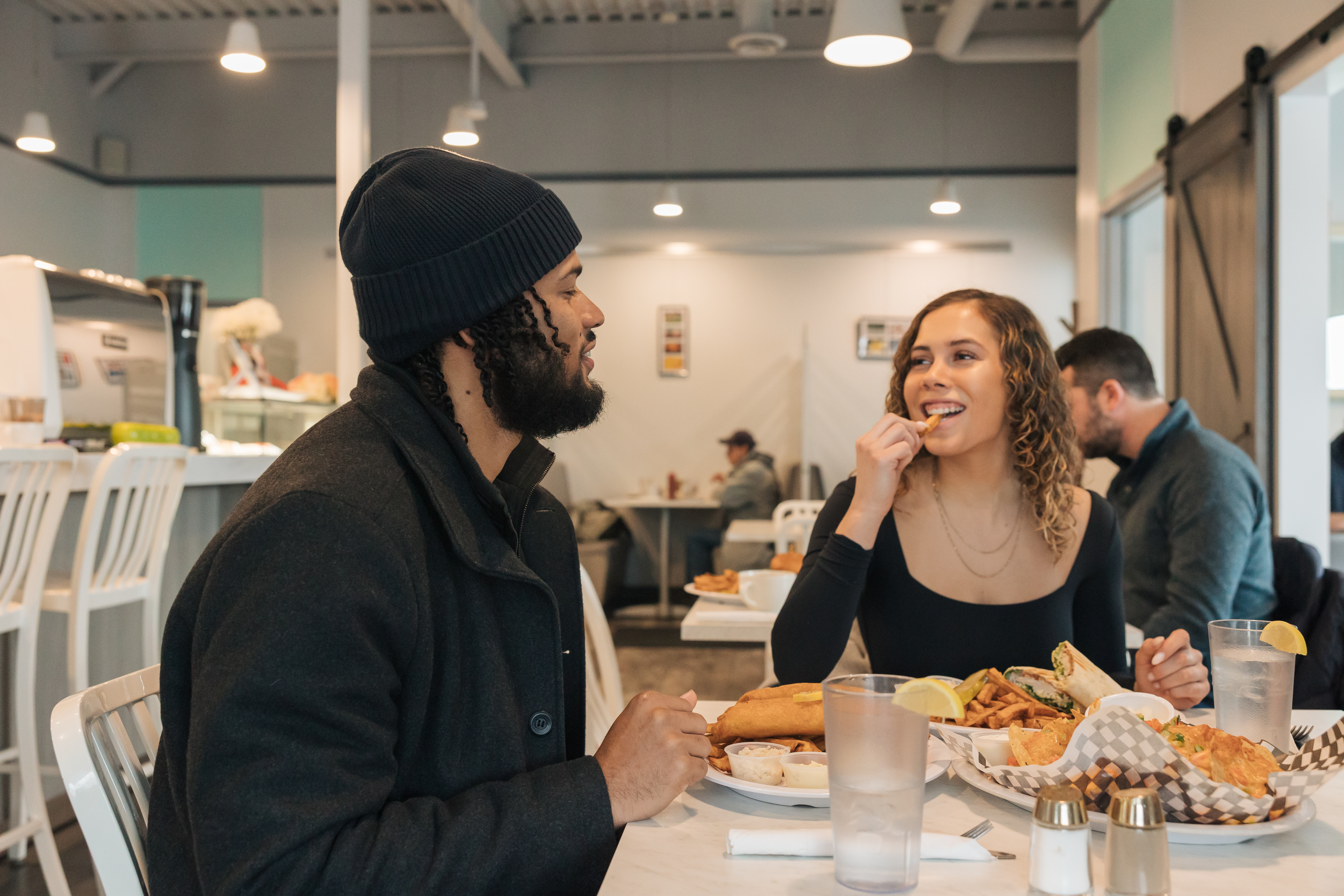 Couple smiling and eating at a white table in the Gold Bean Cafe.