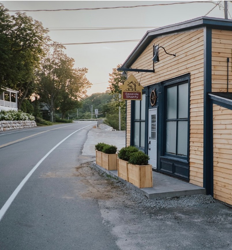 Yellow Seaside Shanty building with black trim and door at sunset.