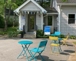 Exterior of The Shop on Central. A grey building with small colourful chairs and tables outside.