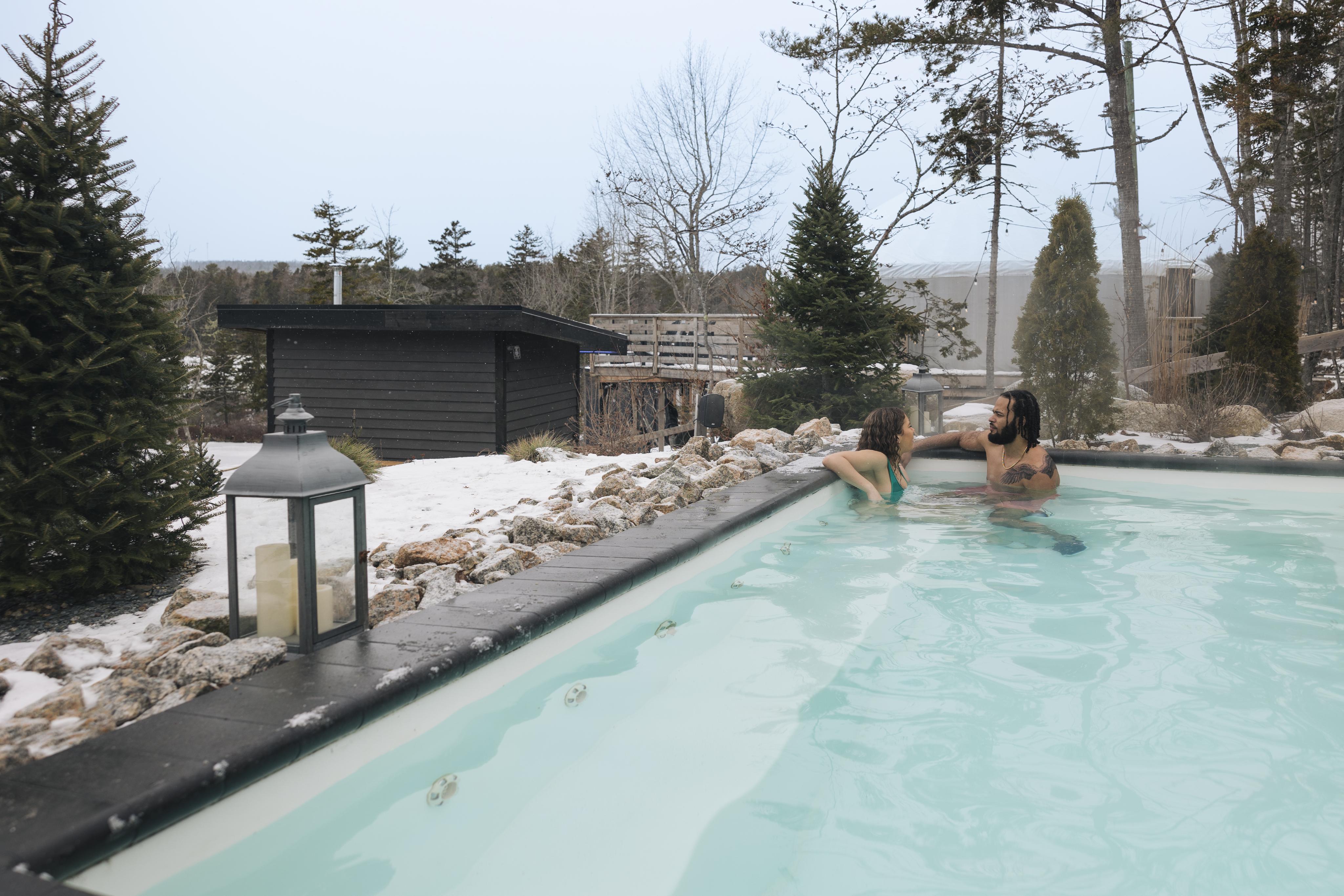 Photo of two people in one of the outdoor heated pool in winter