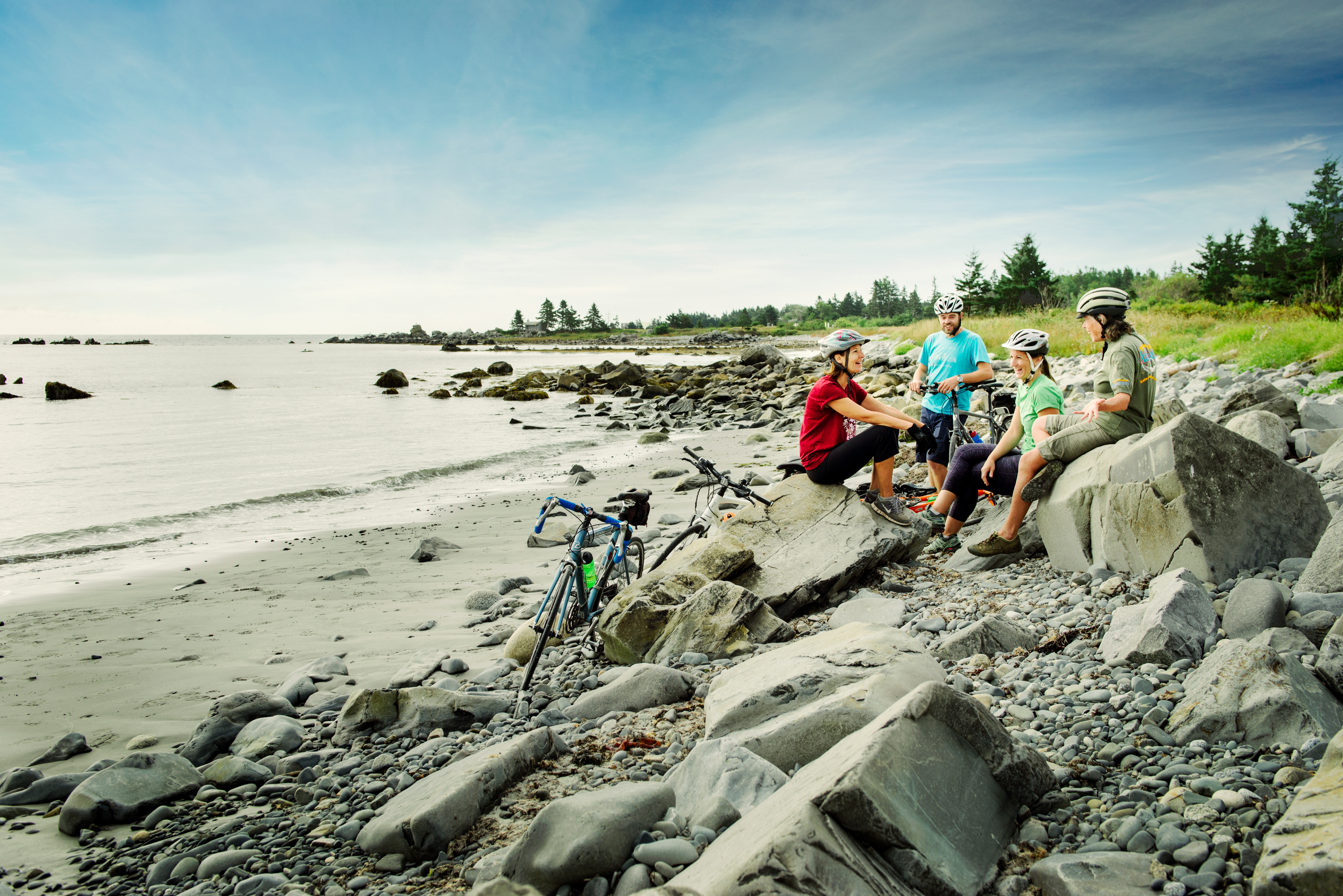 Photo of cyclists taking a break along a rocky beach