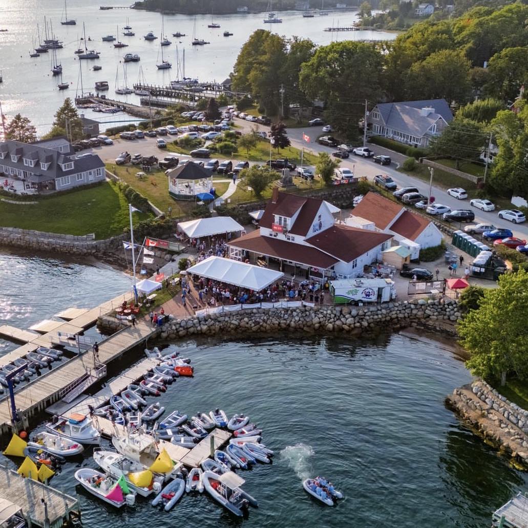 Photo of the Chester Yacht Club during Chester Race Week with tents, people, boats, and music.
