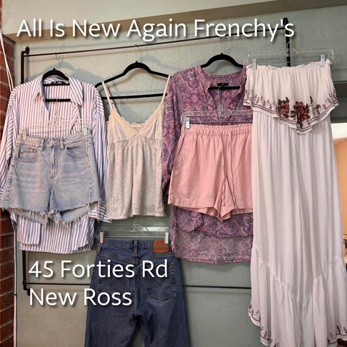 Photo of denim and cotton shorts, jeans, a summer dress and summer tops hanging on display