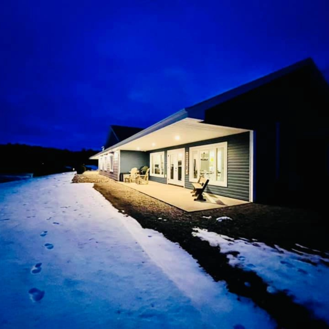Photo of single level blue house and patio overlooking the ocean