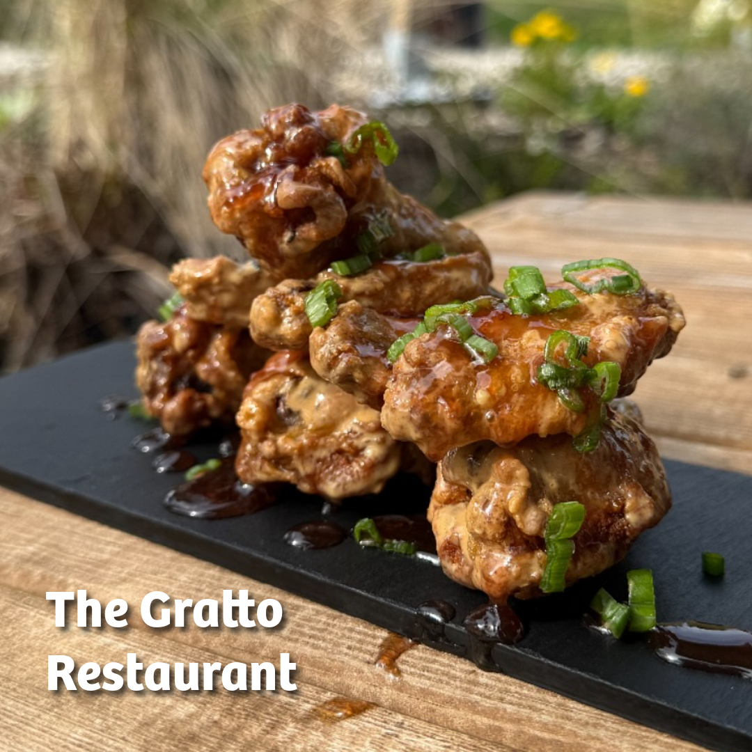 Image features a stack of golden chicken wings on a serving board