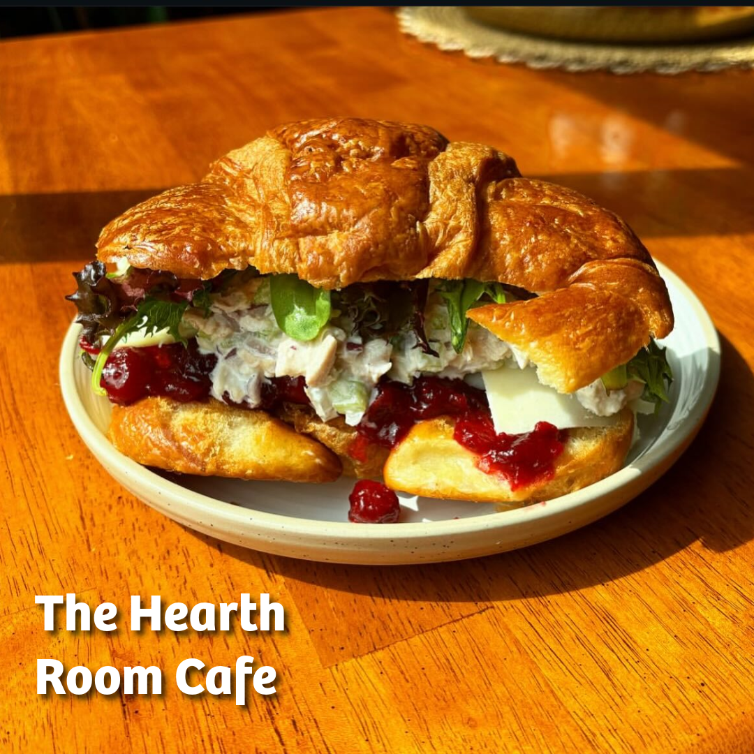 Photo of a croissant sandwich filled with brie, blueberry preserves, and roast chicken