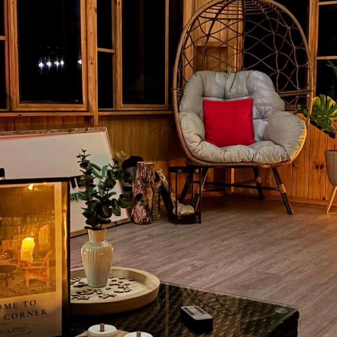 Photo shows the inside of the common room at Dordean Suites, wood floor, soft lighting, seating, nestled in the trees.