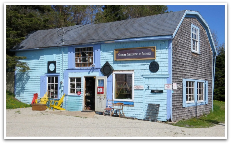 a blue barn style building with a sign on it.