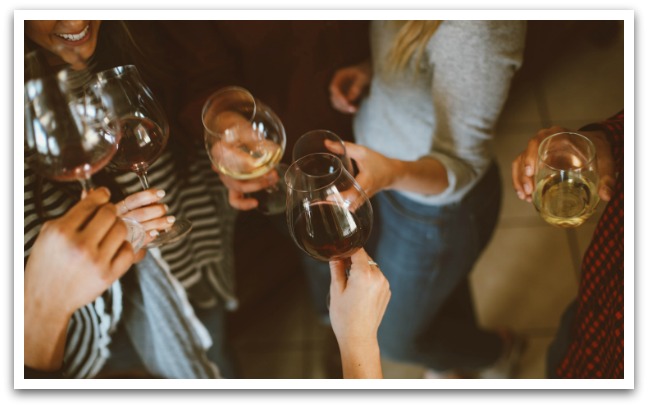 Group of women holding wine glasses of wine.