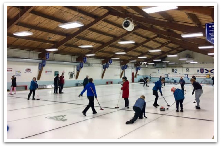 Ice rink with people curling.