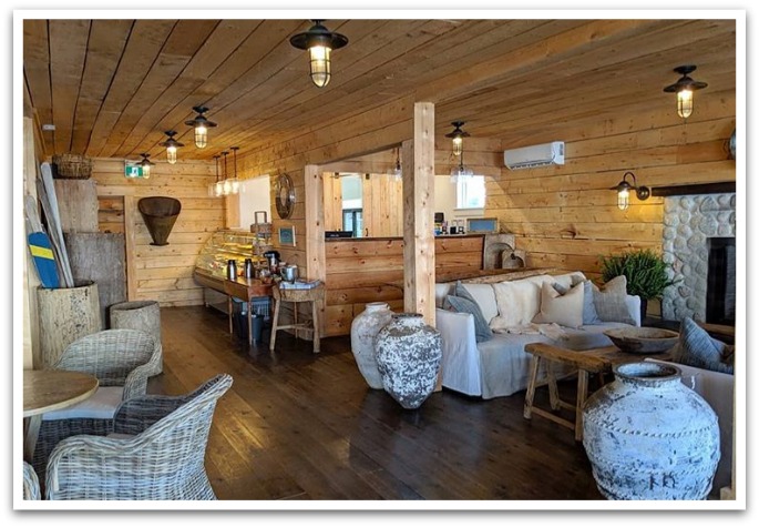 Wood covered interior of the Jib showing a couch and coffee table next to fireplace