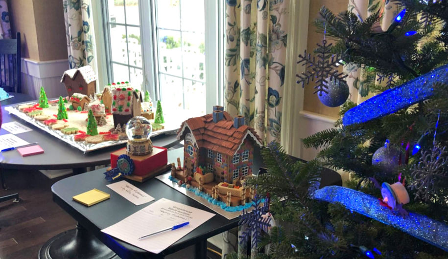 Gingerbread houses next to a Christmas tree.