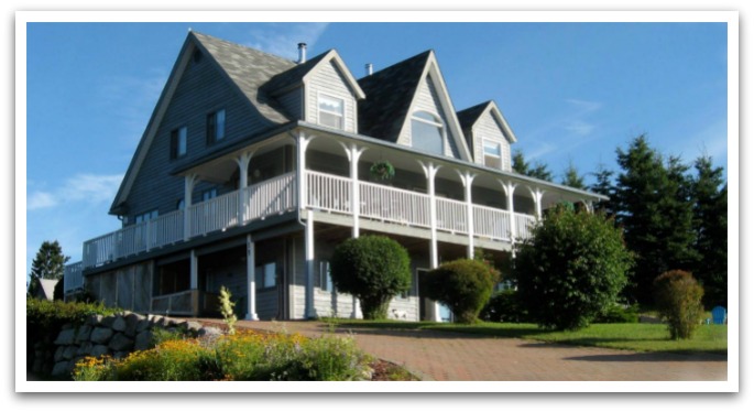 Gray Gables exterior. A gray building with a wrap around terrace.