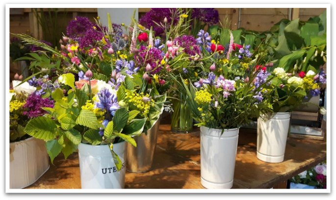 Bouquets of flowers in white, metal vases.