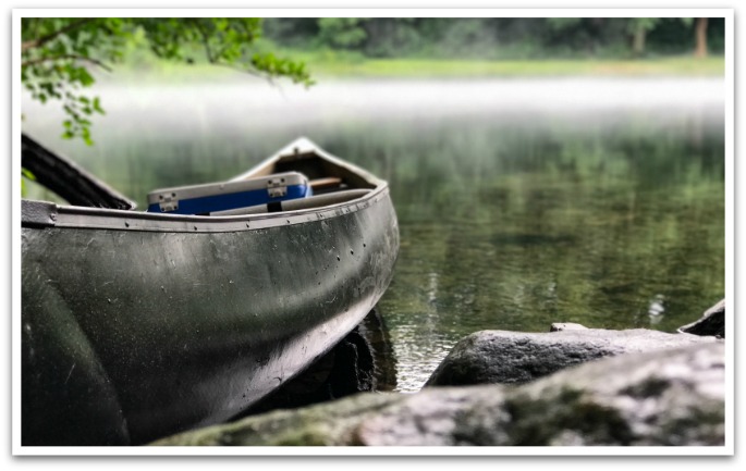 Canoe in a misty lake.
