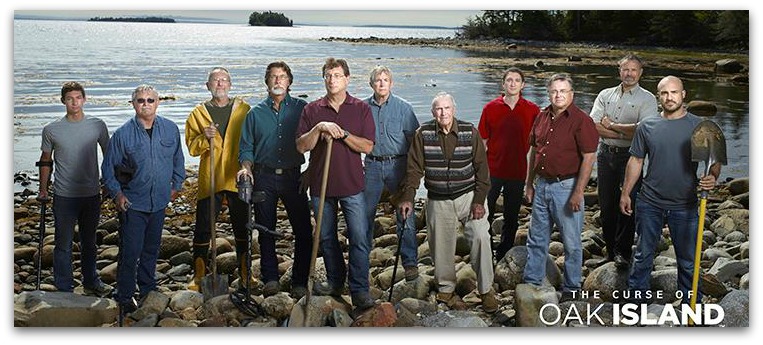 Cast of the Curse of Oak Island TV show standing on a pebble beach with shovels