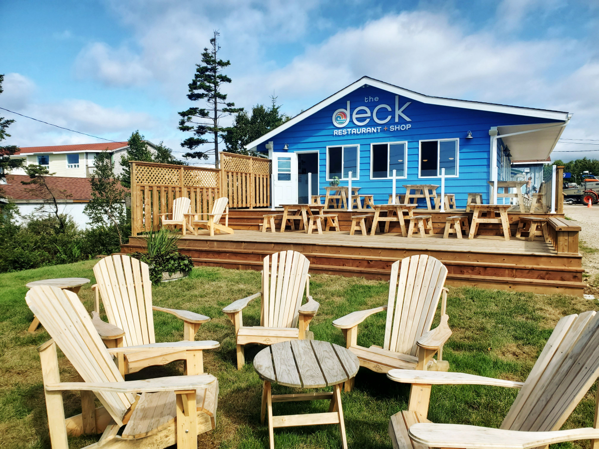 Exterior of The Deck, a blue building, with patio furniture on its deck.