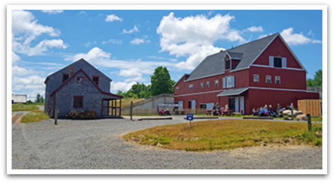 Ross farm main building: a red barn style building next to a grey shed.