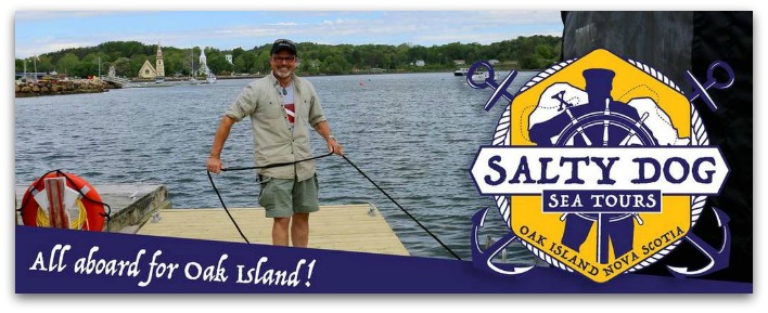Man holding rope and smiling on a wharf with Mahone bay churches in the background. Text over reads "All abord for Oak Island! Salty dog sea tours.
