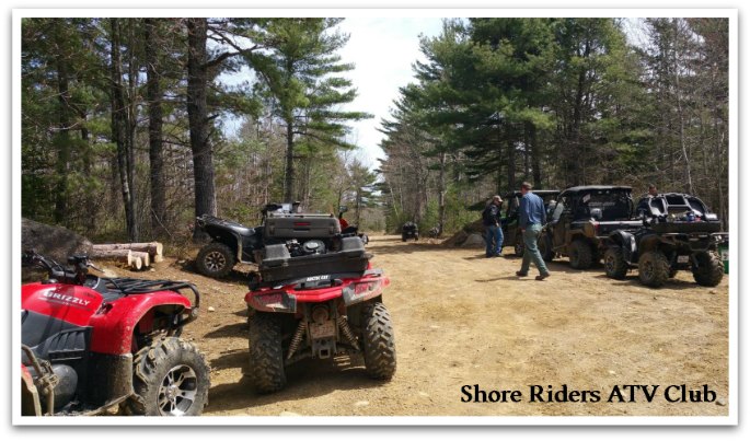 ATVs lining the side of a dirt trail in pine woods. Caption reads "South Riders ATV Club."