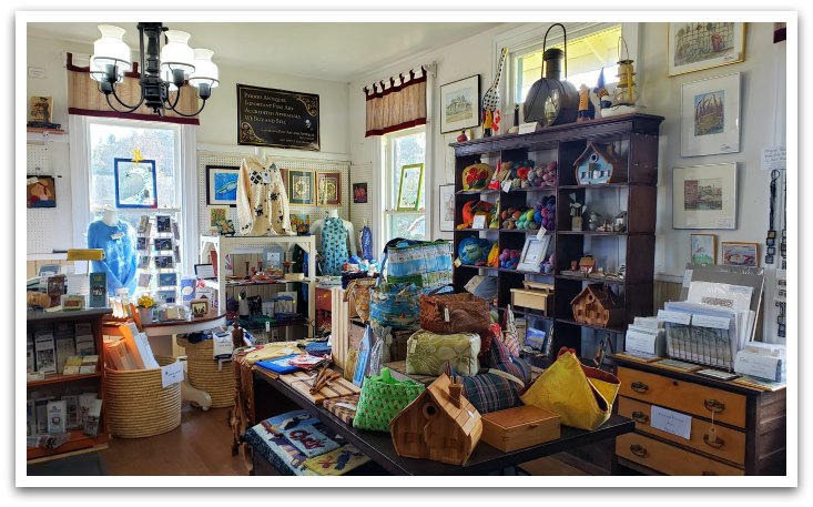 Interior of Station 20, a historic building with chandeliers and white walls filled with crafts and prints.