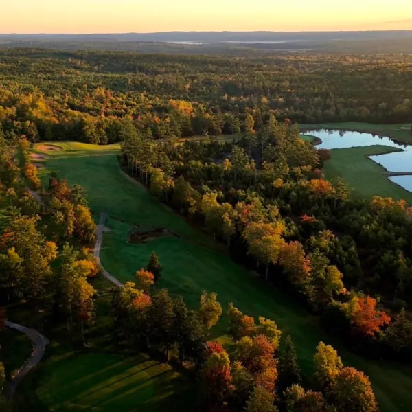 Overhead shot of golf course with autumn trees and a pond
