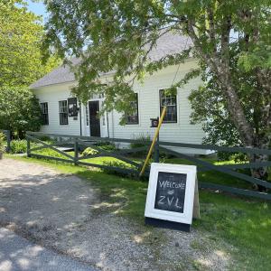 Photo of the outside of Zoe Valle Library, white one story historic house