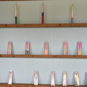 Colourful tapered dip dye candles on shelves