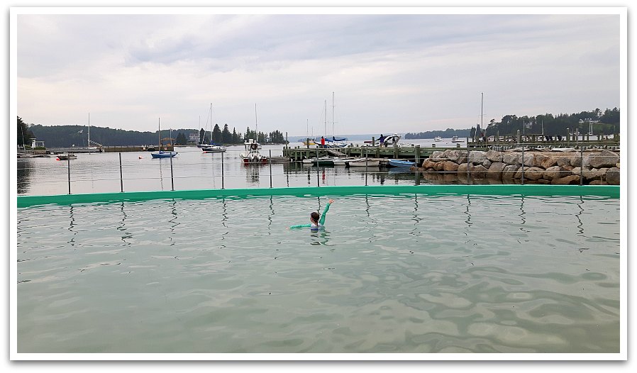 Person in the Lido pool with a few of the harbour and boats