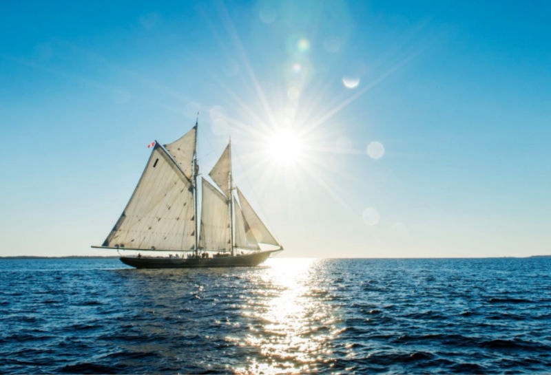 Bluenose II sailboat on the ocean with the sun beaming.
